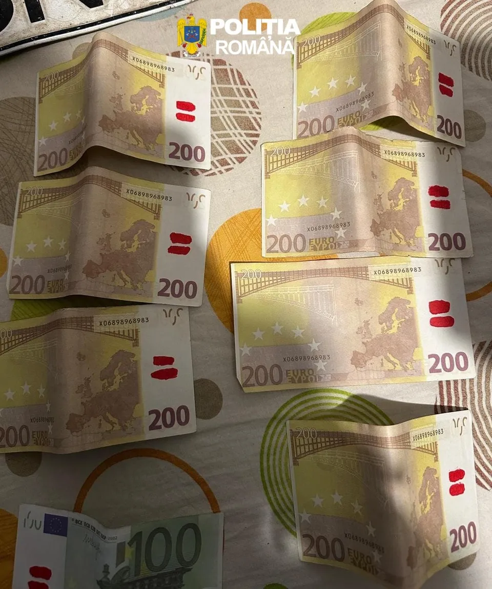 Mai multe bancnote de două sute de euro sunt întinse pe o suprafață cu modele circulare colorate.