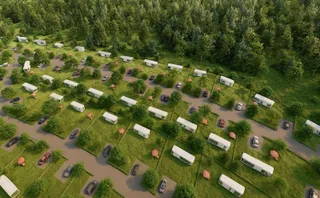 O vedere aeriană prezintă numeroase vehicule albe de tip rulotă parcate pe loturi de teren verde despărțite prin alei și vegetație.