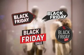 Mai multe etichete grafice cu textul Black Friday sunt suprapuse peste manechinele desfocate dintr-o vitrină de magazin.