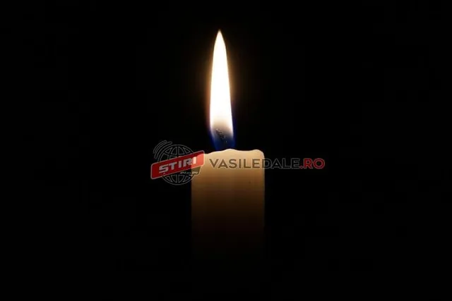 O lumânare aprinsă arde pe un fundal negru.