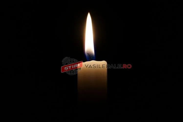 O lumânare aprinsă arde pe un fundal negru.