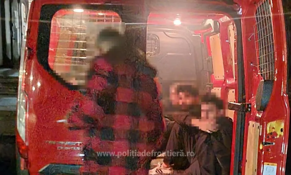 În interiorul unui microbuz roșu sunt văzuți mai mulți oameni, cu fețele estompate, așezați sau în genunchi lângă compartimentul mărfii.