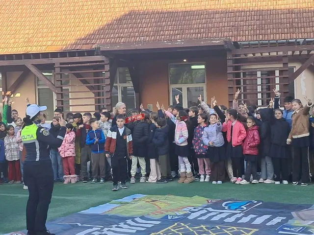 Un grup de elevi stă în fața unei clădiri, ridicând mâinile, în timp ce un polițist stă cu spatele în prim-plan.