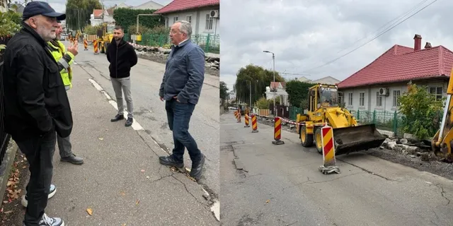 Un grup de bărbați stă pe un drum asfaltat lângă un utilaj de construcții galben și câteva conuri de circulație portocalii.