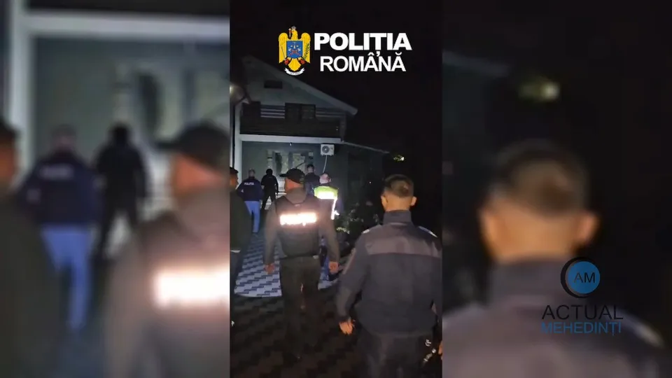 Mai mulți bărbați în uniformă întunecată stau pe un trotuar pavat lângă o clădire, în timpul nopții.