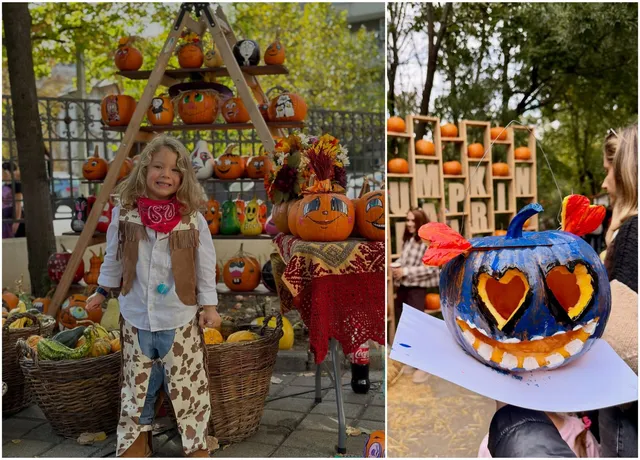 O copilă îmbrăcată în costum de animal stă lângă coșuri cu dovleci și o structură de lemn decorată cu dovleci sculptați.
