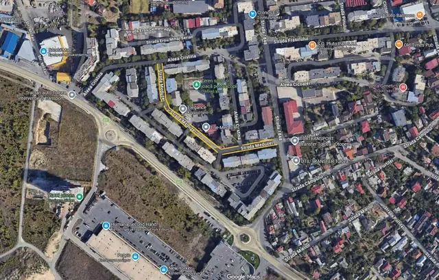 O vedere aeriană a unei zone urbane cu clădiri, străzi, drumuri și vegetație.