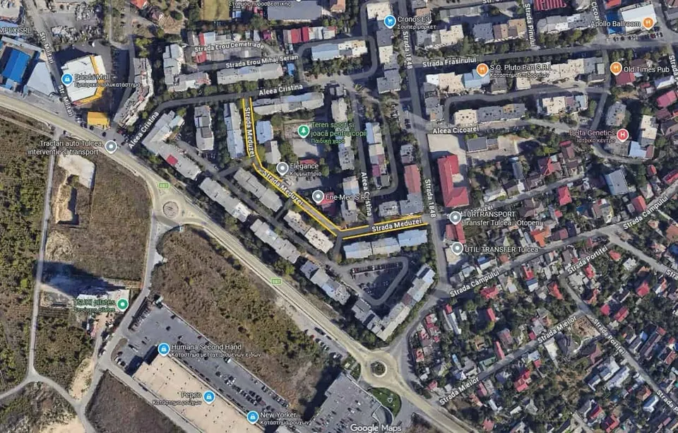 O vedere aeriană a unei zone urbane cu clădiri, străzi, drumuri și vegetație.
