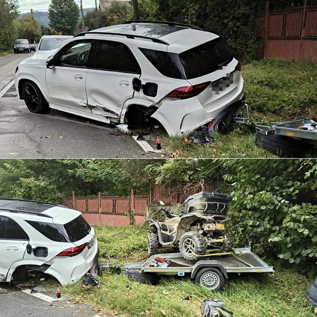 Un autoturism alb cu partea laterală și spatele avariate este oprit pe marginea drumului lângă o remorcă ce transportă un vehicul cu patru roți.