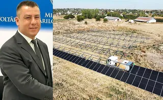 Un bărbat într-un costum gri stă în fața unui fundal albastru, lângă o imagine cu panouri fotovoltaice instalate pe un teren cu iarbă uscată.