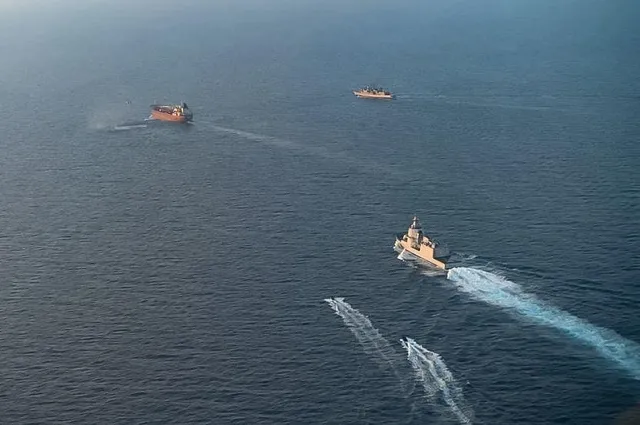 Trei nave navighează pe apă, lăsând urme albe în spate.