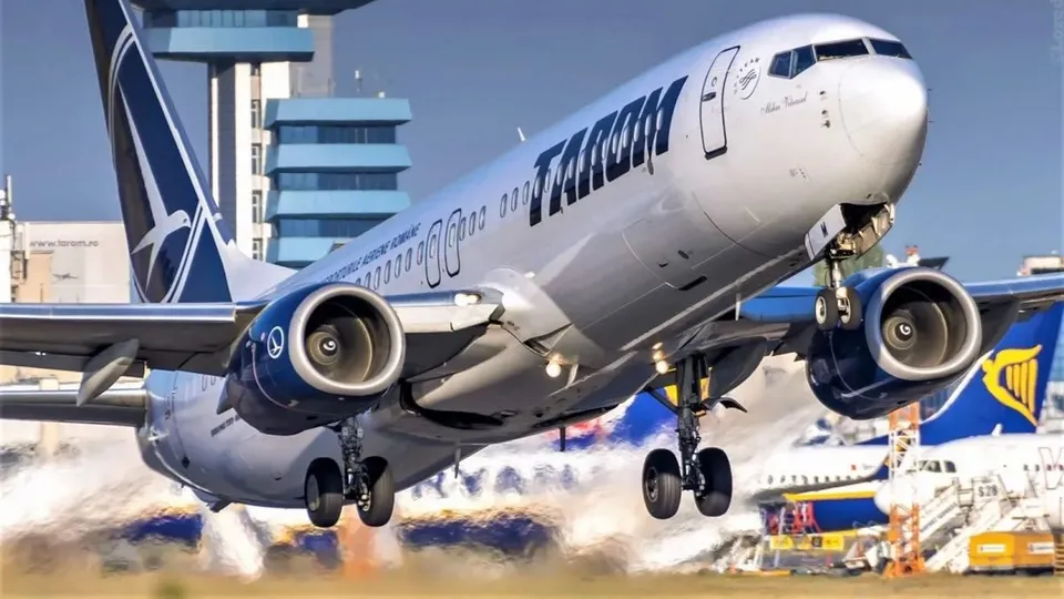 Un avion de pasageri cu inscripția TAROM decolă de pe o pistă, având trenul de aterizare extins.