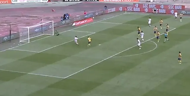 Jucători de fotbal în echipamente albastre și galbene sunt dispersați pe un teren de fotbal verde lângă o poartă de gol.