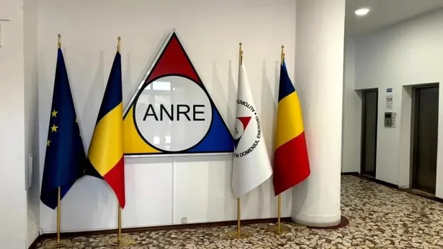 Patru steaguri sunt așezate în dreptul unui panou alb cu un logo triunghiular ce conține textul ANRE.