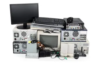 Un monitor negru, tastaturi, mouse-uri și diverse unități de calcul și componente electronice sunt grupate pe un fundal alb.