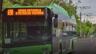 Un troleibuș verde cu afișajul digital numărul 690 și destinația Opera Națională M Petrache Poenaru circulă pe un drum cu copaci în fundal.