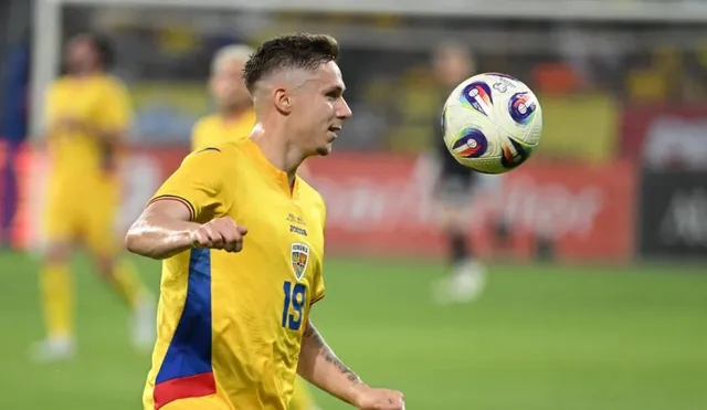 Un jucător de fotbal cu echipament galben și numărul 19 pe tricou privește un balon aflat în aer pe un teren de fotbal.