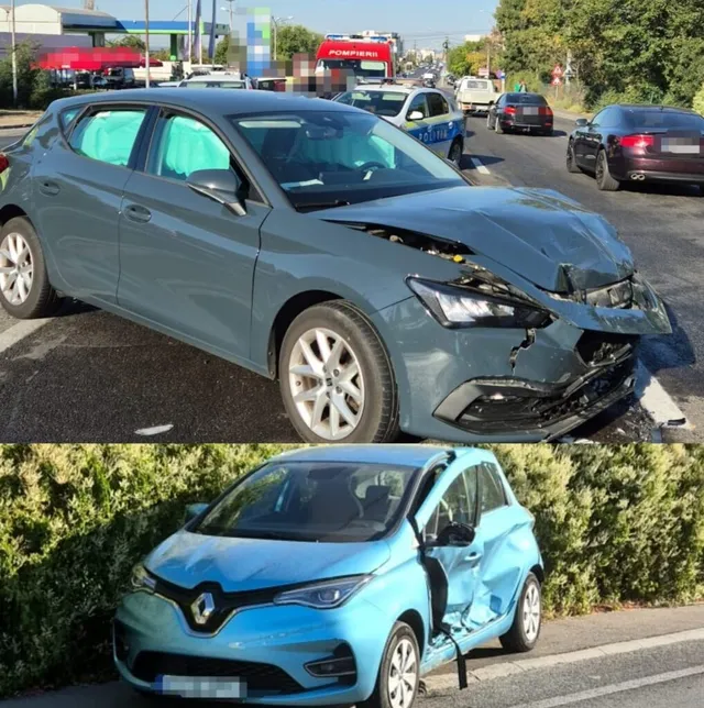Două autoturisme de culoare gri și albastră prezintă daune la partea frontală și laterală pe un drum asfaltat lângă un gard de vegetație.
