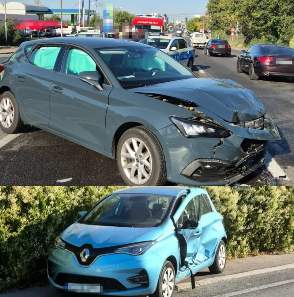 Două autoturisme de culoare gri și albastră prezintă daune la partea frontală și laterală pe un drum asfaltat lângă un gard de vegetație.