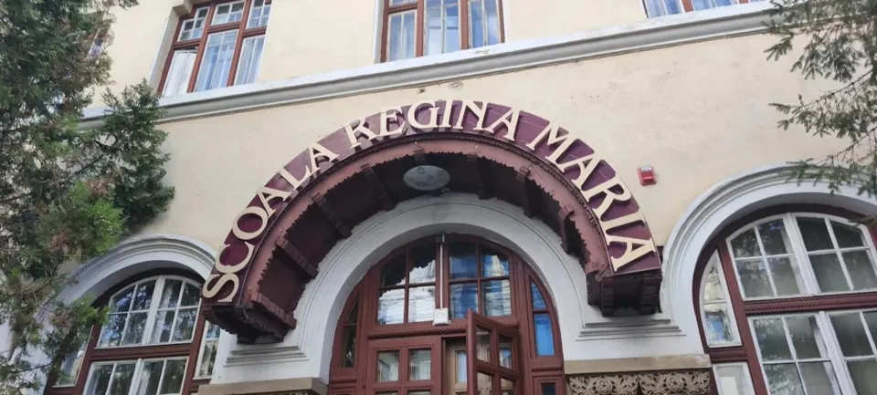 O clădire cu ferestre mari și un arc de intrare pe care este scris textul SCOALA REGINA MARIA.
