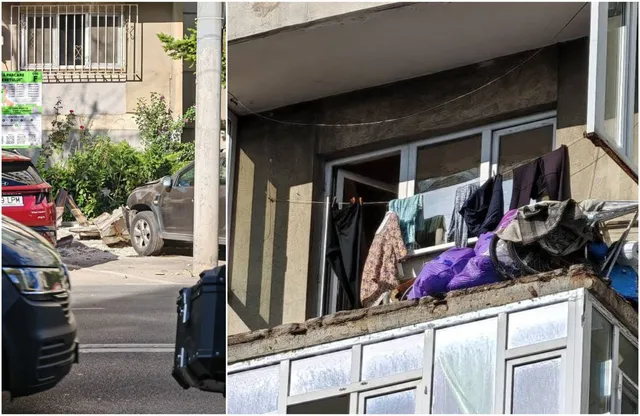 Un balcon cu haine întinse este situat deasupra unui trotuar unde se află mașini parate și resturi de beton pe sol.