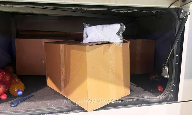 În interiorul unui compartiment, trei cutii de carton maro sunt așezate lângă obiecte colorate și un obiect lung și subțire.