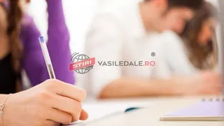 O mână ține un pix albastru deasupra unui suport de scris, în timp ce în fundal apar persoane desfășurând activități la masa de lucru.