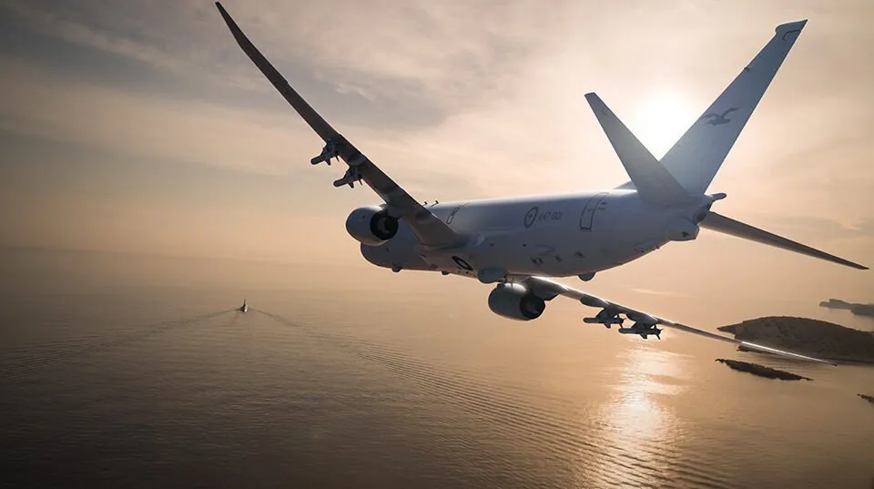 Un avion de pasageri zboară deasupra unei mări sub un cer luminos la apus.