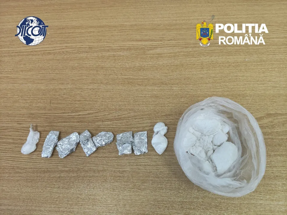 Mai multe porții învelite în folie de aluminiu și un sac transparent conținând o substanță albă sunt așezate pe o suprafață de lemn.