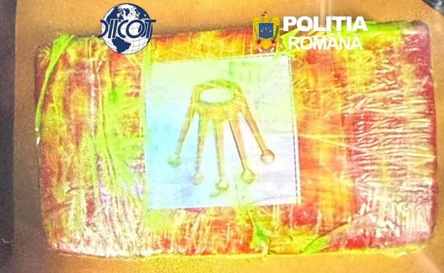 Un obiect dreptunghiular învelit în folie colorată prezintă un desen cu un obiect galben pe un fundal alb.