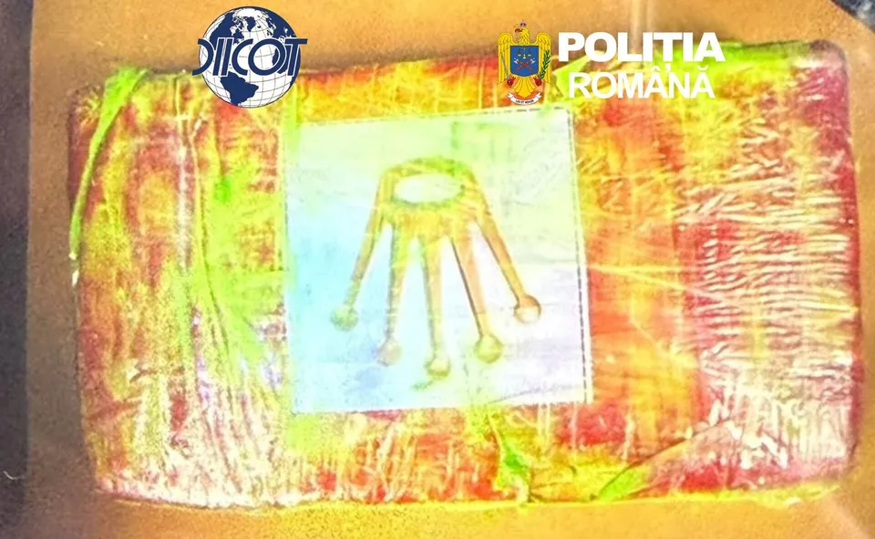 Un obiect dreptunghiular învelit în folie colorată prezintă un desen cu un obiect galben pe un fundal alb.