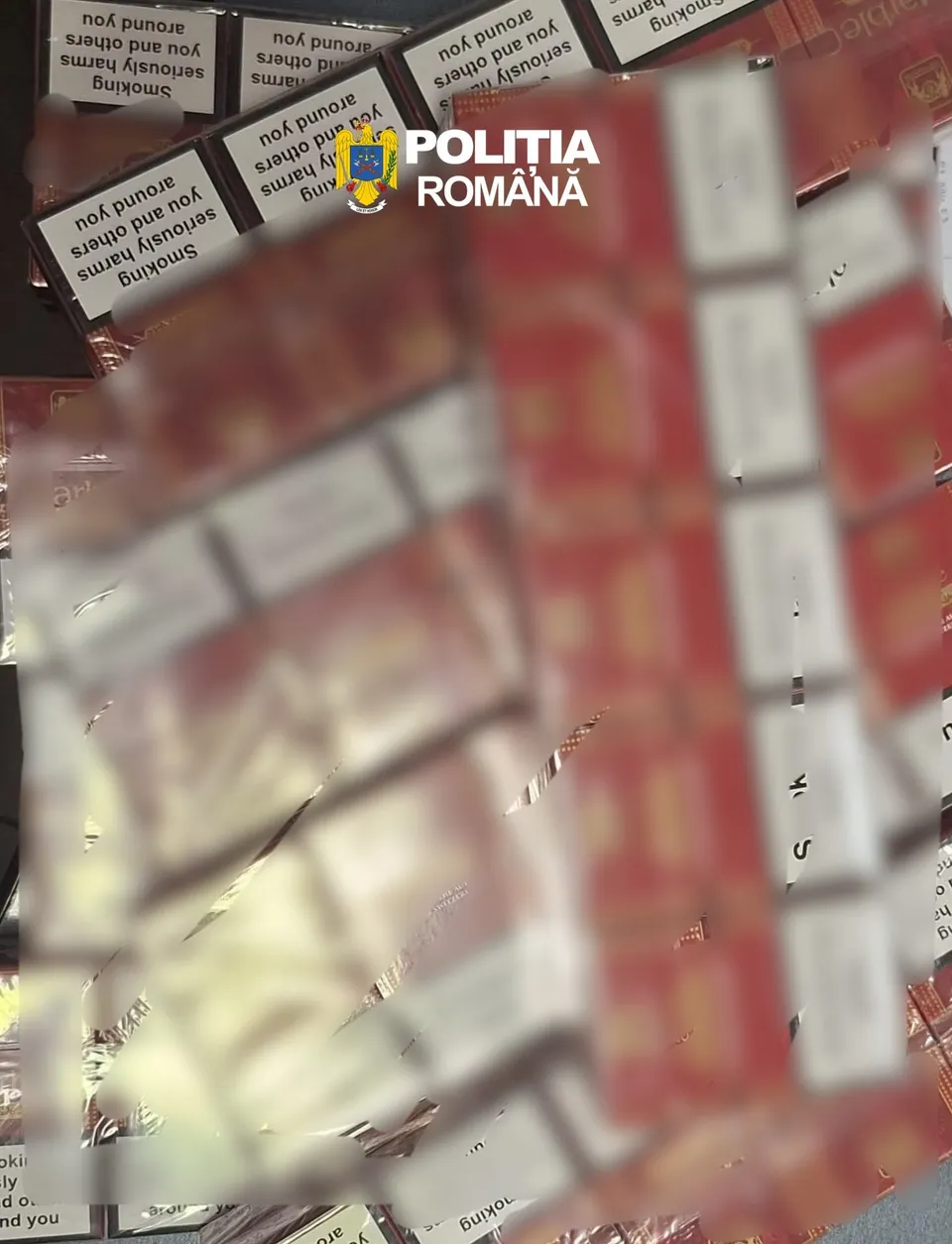 Multe pachete de țigări roșii și albe sunt așezate pe o suprafață plană.