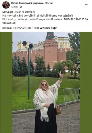 O femeie cu ochelari de soare, purtând o rochie neagră și un șal alb, stă pe un drum pavat în fața unei clădiri din cărămidă roșie.