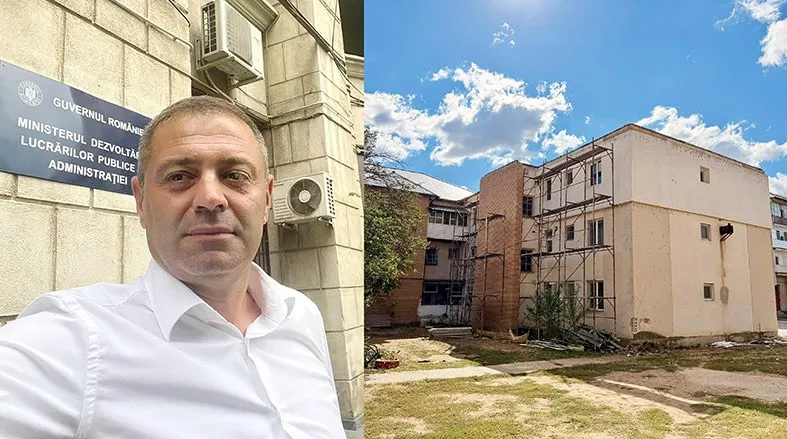 Un bărbat în cămașă albă stă în fața unui imobil cu un panou informativ, iar în partea dreaptă se vede o clădire cu schele exterioare.