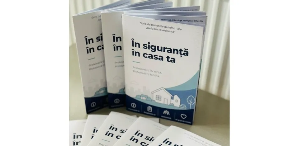 Mai multe broșuri albe cu text albastru și ilustrații de case sunt așezate pe o suprafață plană.