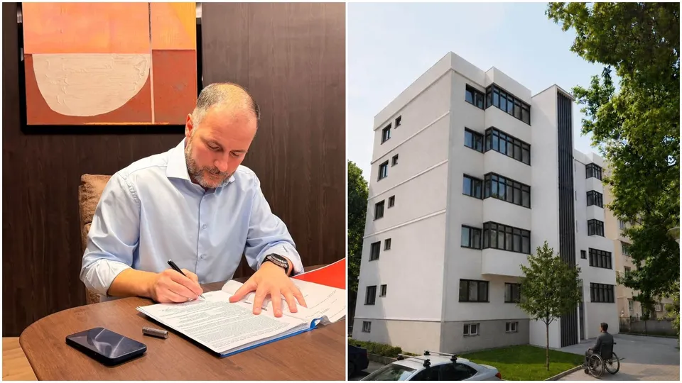 Un bărbat cu cămașă albastră semnează un document la o masă de lemn lângă un tablou abstract.