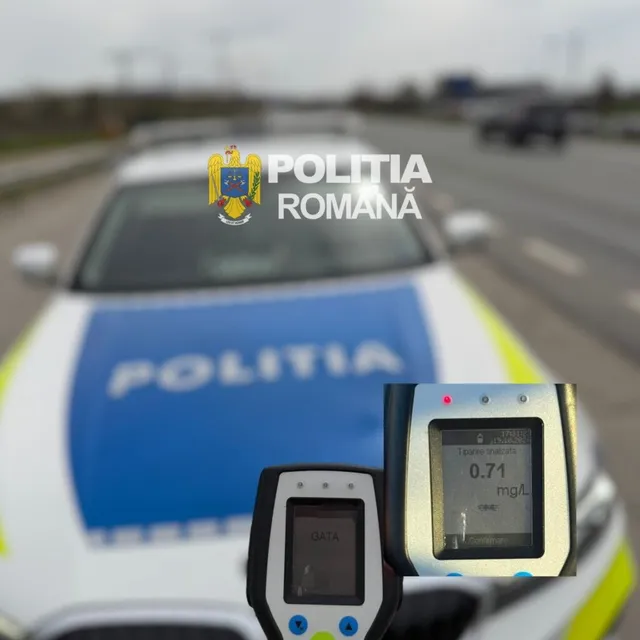 Un aparat de măsurat alcoolemia afișează valoarea 0.71 mg/L în prim-plan, în fața unui autovehicul de poliție albastru și alb.